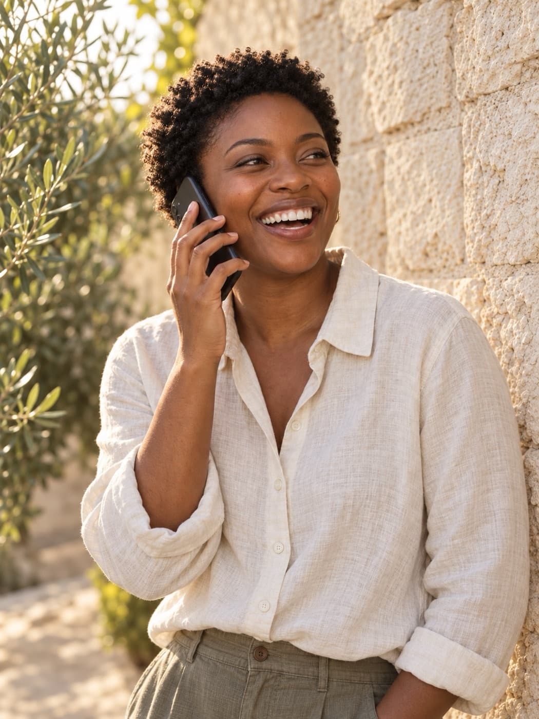 Person laughing during a phone call outdoors